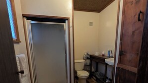 A bathroom with a shower, toilet, and sink.