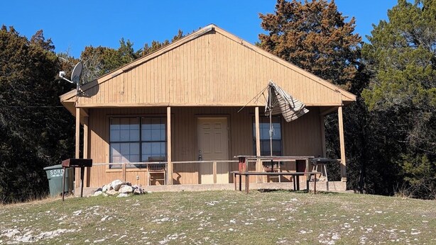 A wooden cabin with a porch, large windows, and a picnic table. - Mountain View 2 Bed Cabin (Davis)