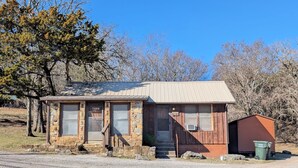 A small stone cabin with a metal roof, a wooden door, and a window labeled "CABIN #2". - The Most Beautiful Views in Turner Falls (Davis)