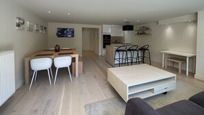 Un appartement moderne comprenant un coin repas, une cuisine et un espace de vie.