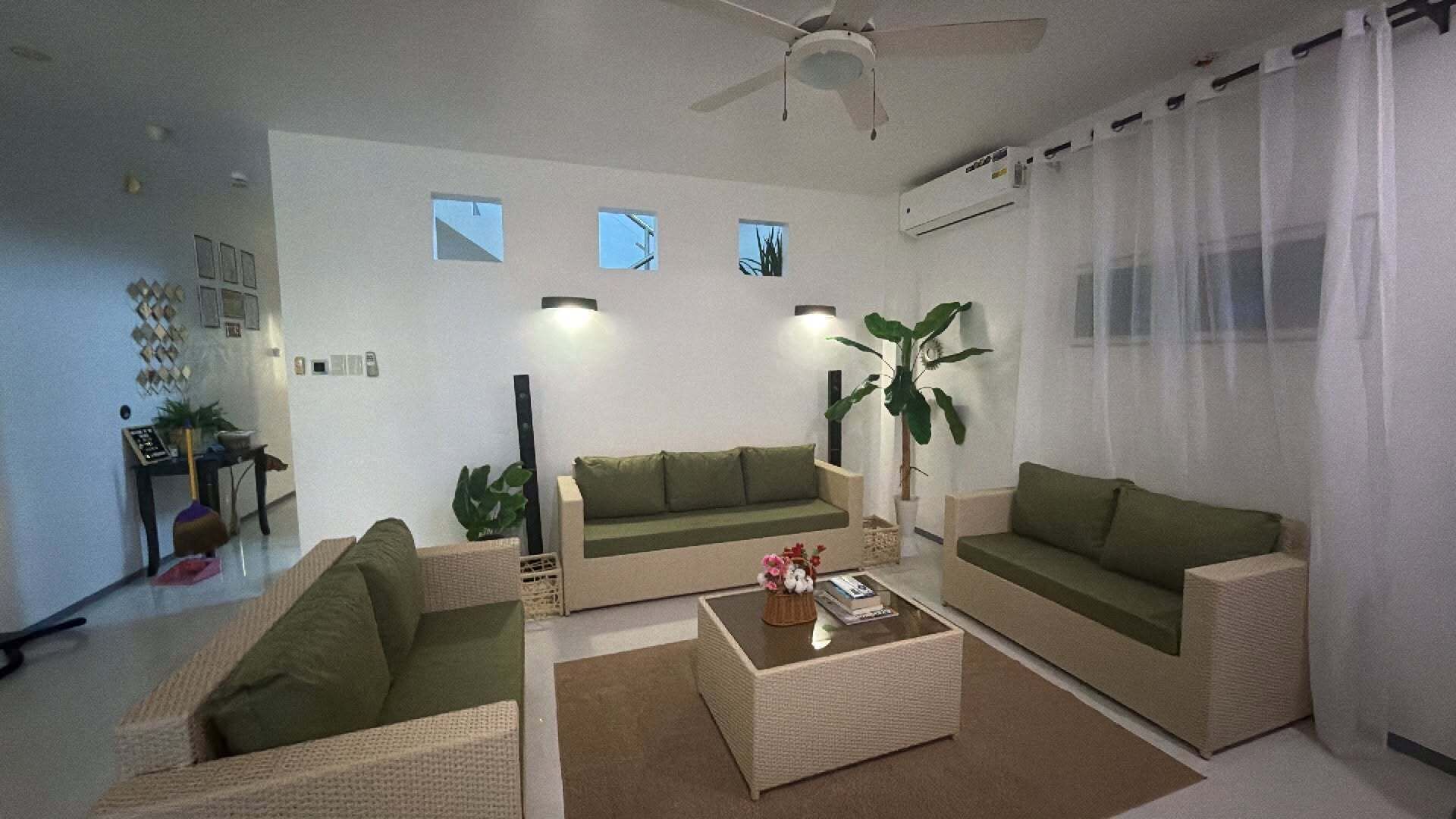 Un salon avec deux canapés, une table basse et un ventilateur de plafond.