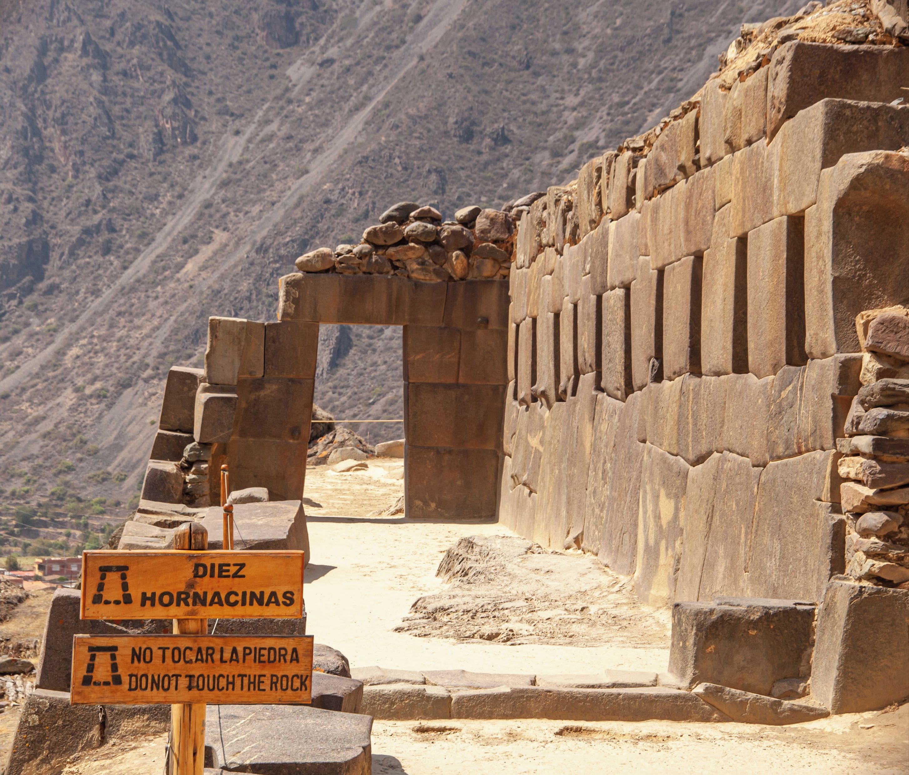 An ancient stone structure with warning signs.