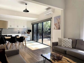 Un espacio de estar moderno con comedor, sofá y cocina.