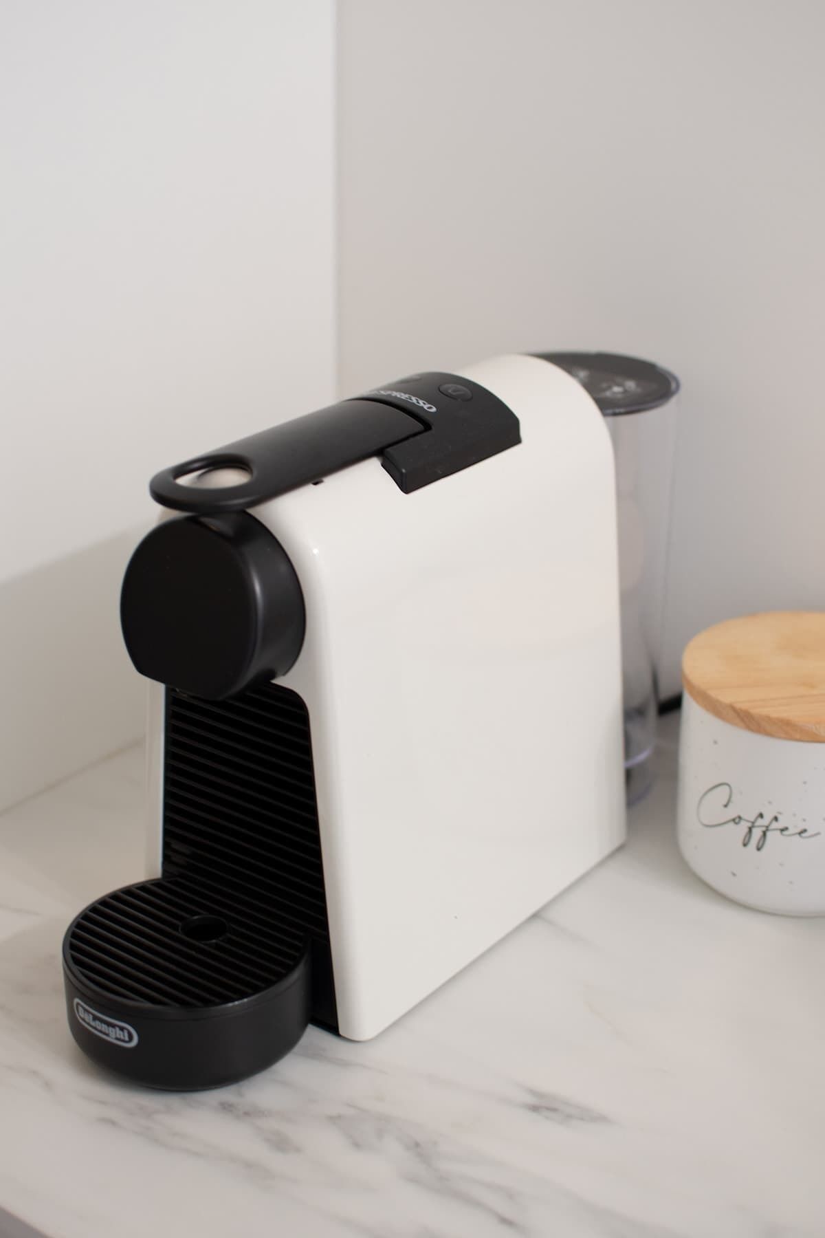 A coffee maker on a white countertop with a marble-like surface.