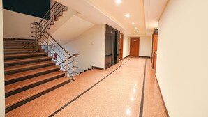 Un intérieur moderne avec un escalier, un couloir et une porte.