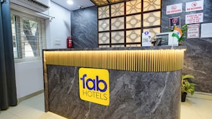A hotel reception desk with a marble counter, a check-in window, and various signs including no smoking and no alcohol policies. - Fabhotel Living Tree (Hyderabad)