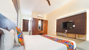 Ein Hotelzimmer mit Bett, Wandfernseher und Kleiderschrank.
