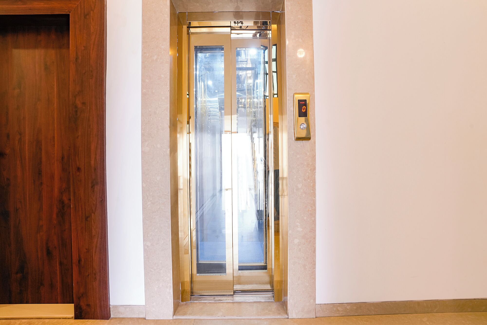 An elevator with a glass door and a control panel on the wall.