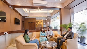 A modern lobby with leather sofas, a marble coffee table, and a large mirror. - Fabhotel Sunshine Residency (Navi Mumbai)