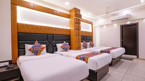 A hotel room with three beds, each with a unique geometric-patterned pillow. - Fabhotel Sunshine Residency (Navi Mumbai)