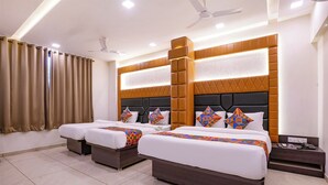 A hotel room with two beds, a large window with curtains, a ceiling fan, and a bedside table with a phone and charger. - Fabhotel Sunshine Residency (Navi Mumbai)