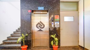 Ascensore con un cartello 'LIFT', un cartello 'NO GROUNDING' e un cartello 'NO VISITORS ALLOWED'.