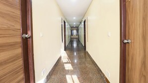 Un largo pasillo estrecho con puertas de madera a ambos lados y un suelo pulido.
