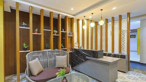 Un área de recepción con un sofá, una mesa de vidrio y un mostrador.