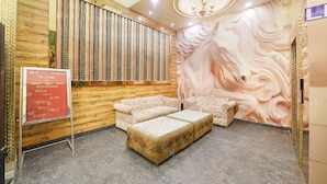 Un vestíbulo de hotel con una pared de madera, un mural grande, un mostrador de recepción y una zona de estar.