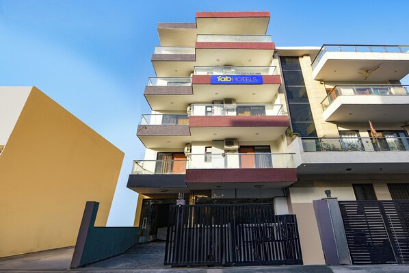 A multi-story hotel with a modern design, featuring balconies on each floor and a visible sign for 'Tab Hotels'. - Fabhotel Kesari Stayz (Gurugram)