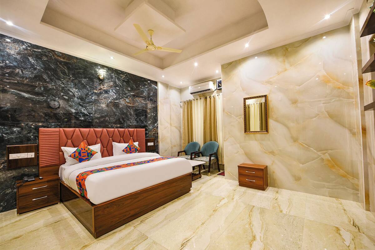 A modern bedroom with a marble wall, a wooden bed, and a ceiling fan.