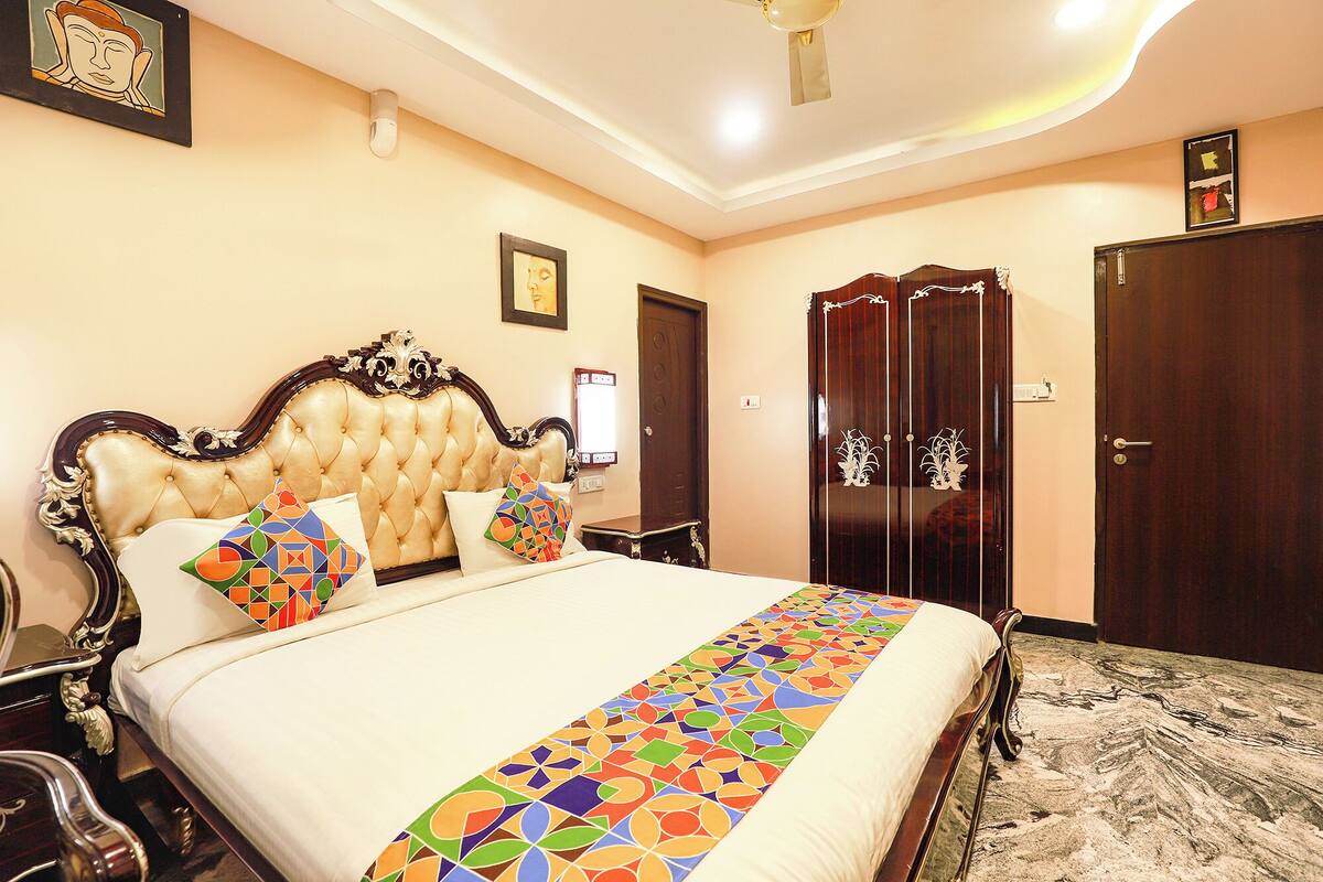 A hotel room with a large bed, a wardrobe, and a mirror.