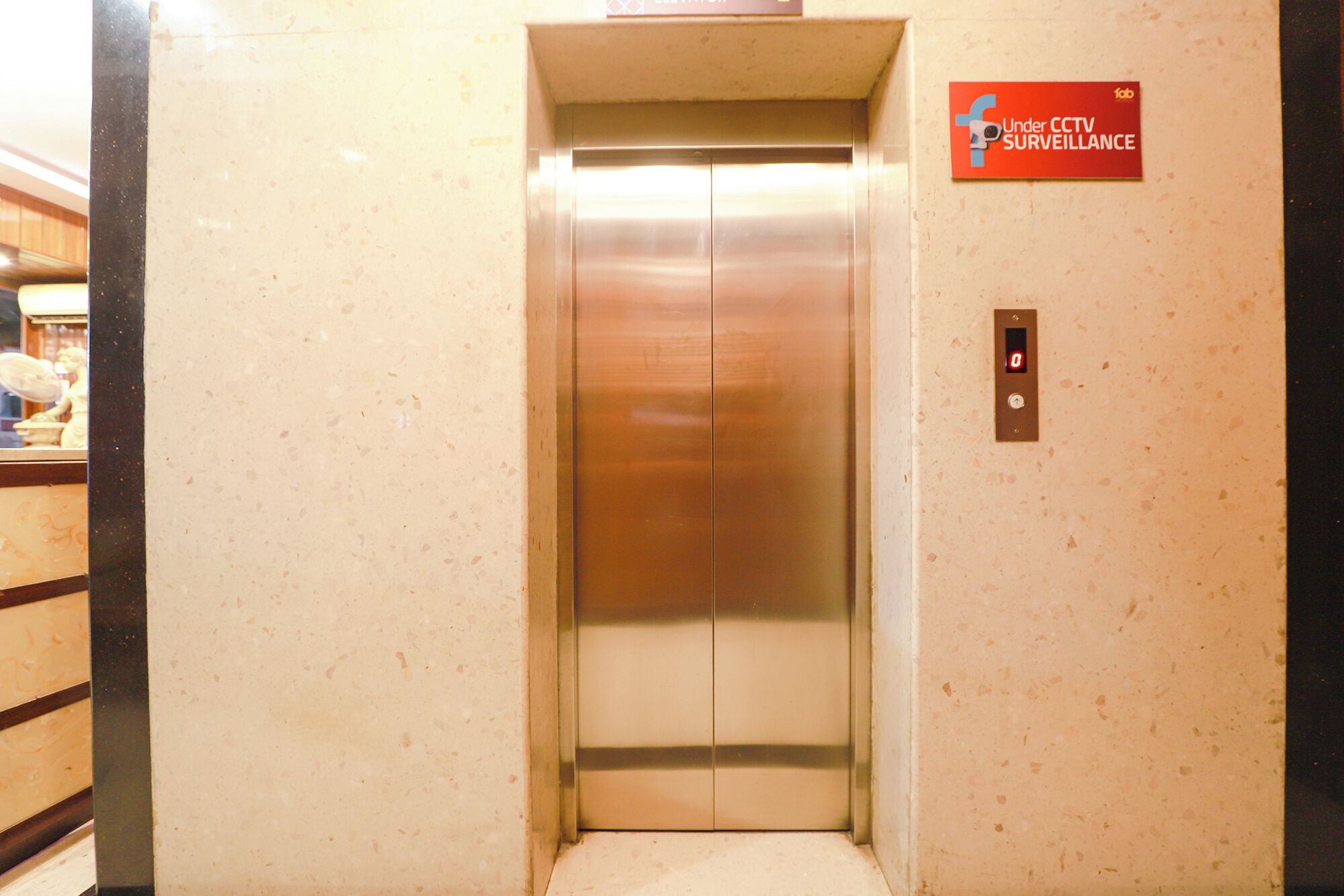 Un ascensor con un cartel que indica videovigilancia.