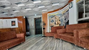 A lobby with a patterned ceiling, a mural on the wall, and a wooden reception desk. - Fabhotel Devpriya (Chhatrapati Sambhajinagar)