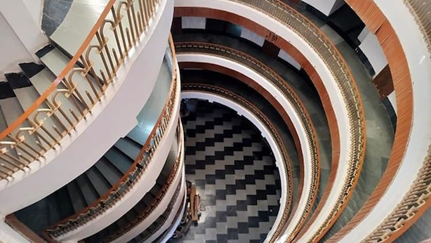 A multi-level spiral staircase with ornate railings and a checkered floor pattern. - Fabhotel Devpriya (Chhatrapati Sambhajinagar)