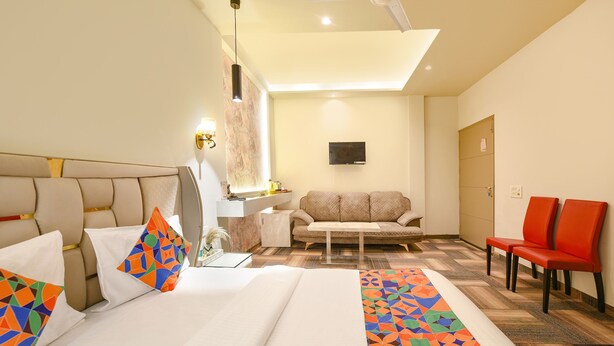 A hotel room with a bed, a sofa, a desk, and a TV. - Fabhotel Vintage Inn (New Delhi)