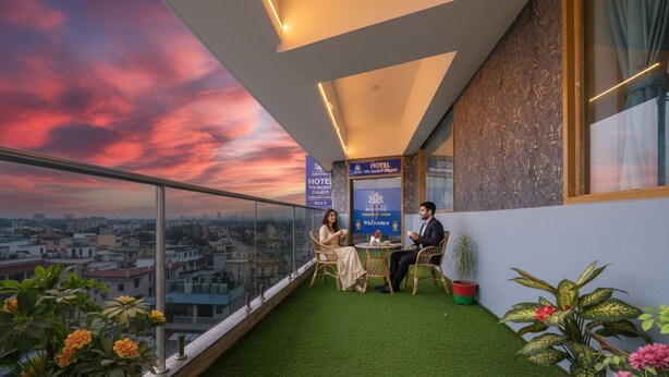 Una habitación de hotel con vistas a la ciudad, un balcón con césped artificial y plantas en macetas.