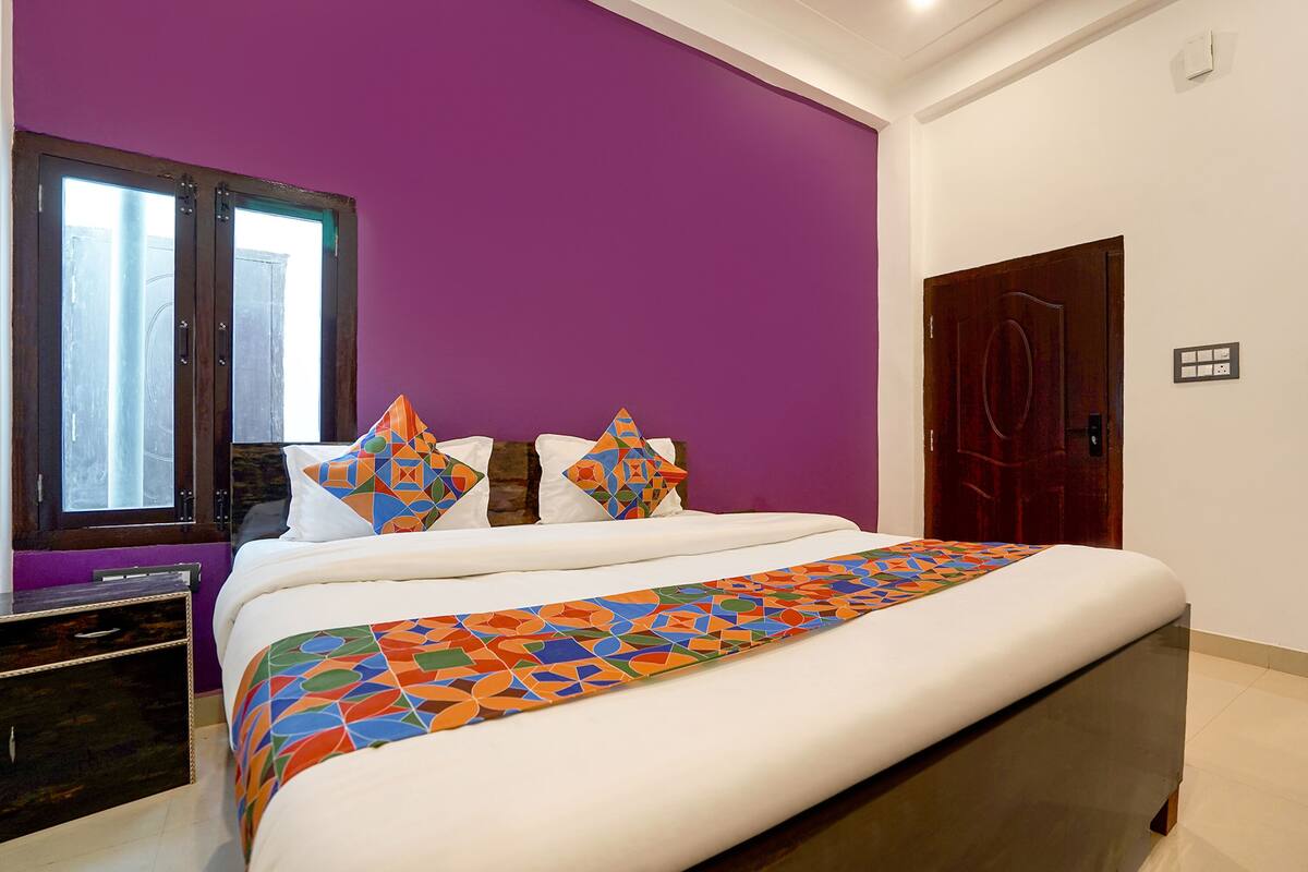 A bedroom with a bed, a window, and a door.