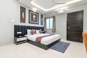 Un dormitorio moderno con una cama, mesitas de noche, ventilador de techo y una ventana con cortinas.