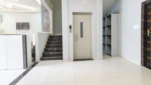 En moderne lobby med reception, trappe og et overvågningskamera.