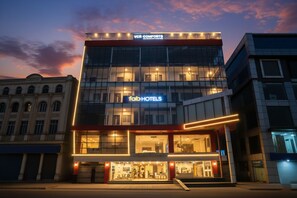 Un hotel moderno con fachada de vidrio, señalización 'VCR COMFORTO' y marca 'fabHOTELS'.
