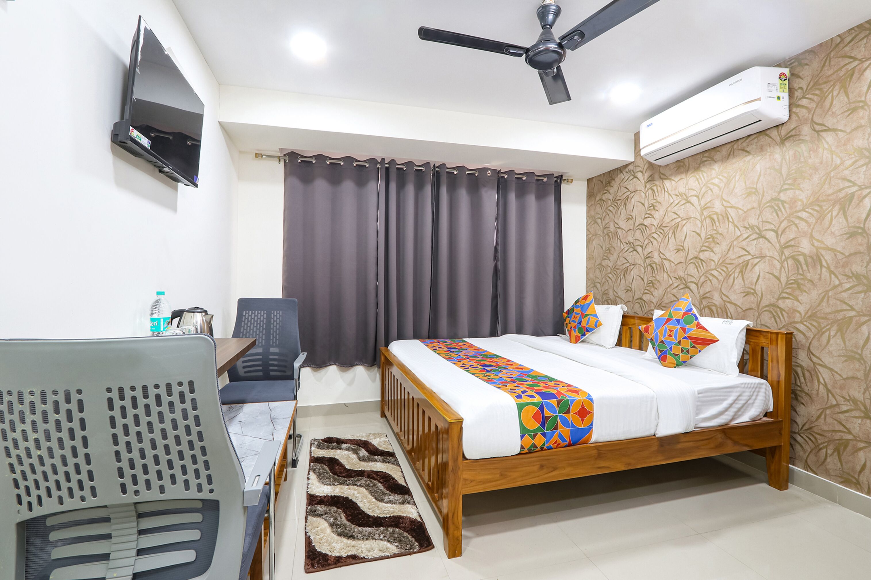 Un dormitorio con cama, escritorio, silla, ventilador de techo y aire acondicionado.