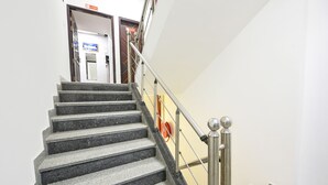 A staircase with metal railings and a handrail, leading to an interior space. - Fabhotel Silver Stone (Noida)