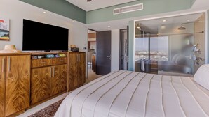 Un dormitorio moderno con una cama grande, un armario de madera y un televisor.