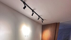Een moderne woonkamer met een hoekbank, een bijzettafeltje en een potplant.