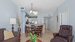 A living room with a brown leather sofa, a dining table with chairs, a leather recliner, and a potted plant. - Oceanfront Condo w/ Pool + Pier Park Access Front Beach Retreat by Avantstay (Panama City Beach)