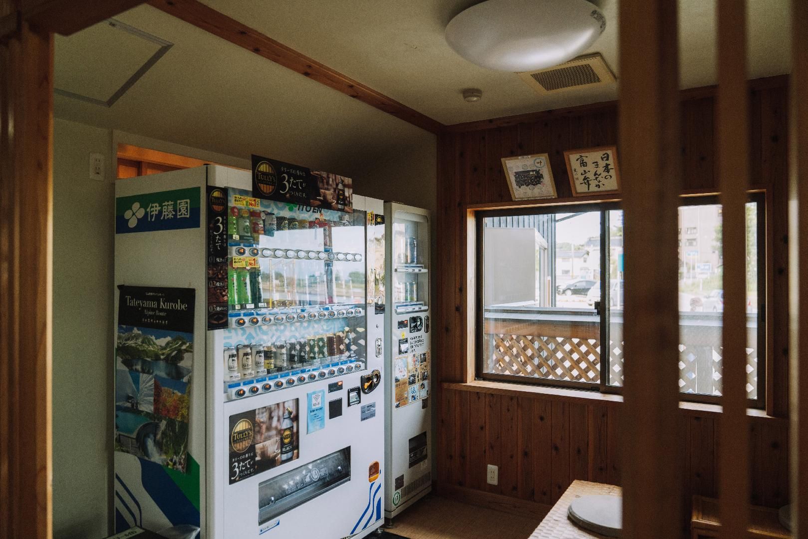Ein Zimmer mit Getränke- und Snackautomaten, Holzvertäfelung und einem Fenster mit Blick nach draußen.
