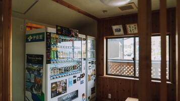 Ein Zimmer mit Getränke- und Snackautomaten, Holzvertäfelung und einem Fenster mit Blick nach draußen.