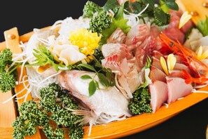 A wooden platter with various seafood and vegetables. - Wafu Onsen Motoyu Kano (Himi)