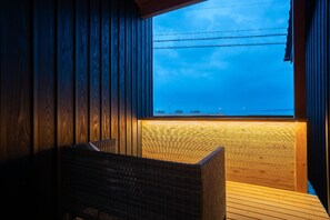 A wooden interior with a view of the sea through a window. - Wafu Onsen Motoyu Kano (Himi)