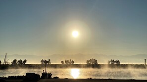 A sunrise over a body of water with mountains in the background. - Wafu Onsen Motoyu Kano (Himi)