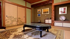 A traditional Japanese room with tatami flooring, a low table, and sliding doors. - Kashibesso Sakuraso (Beppu)