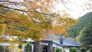 A traditional Japanese-style building with a dark roof and a wooden entrance. - Goroku Onsen (Tsuno)