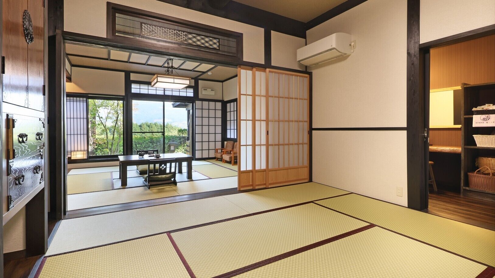 A traditional Japanese room with tatami flooring, sliding doors, and a view of a garden.