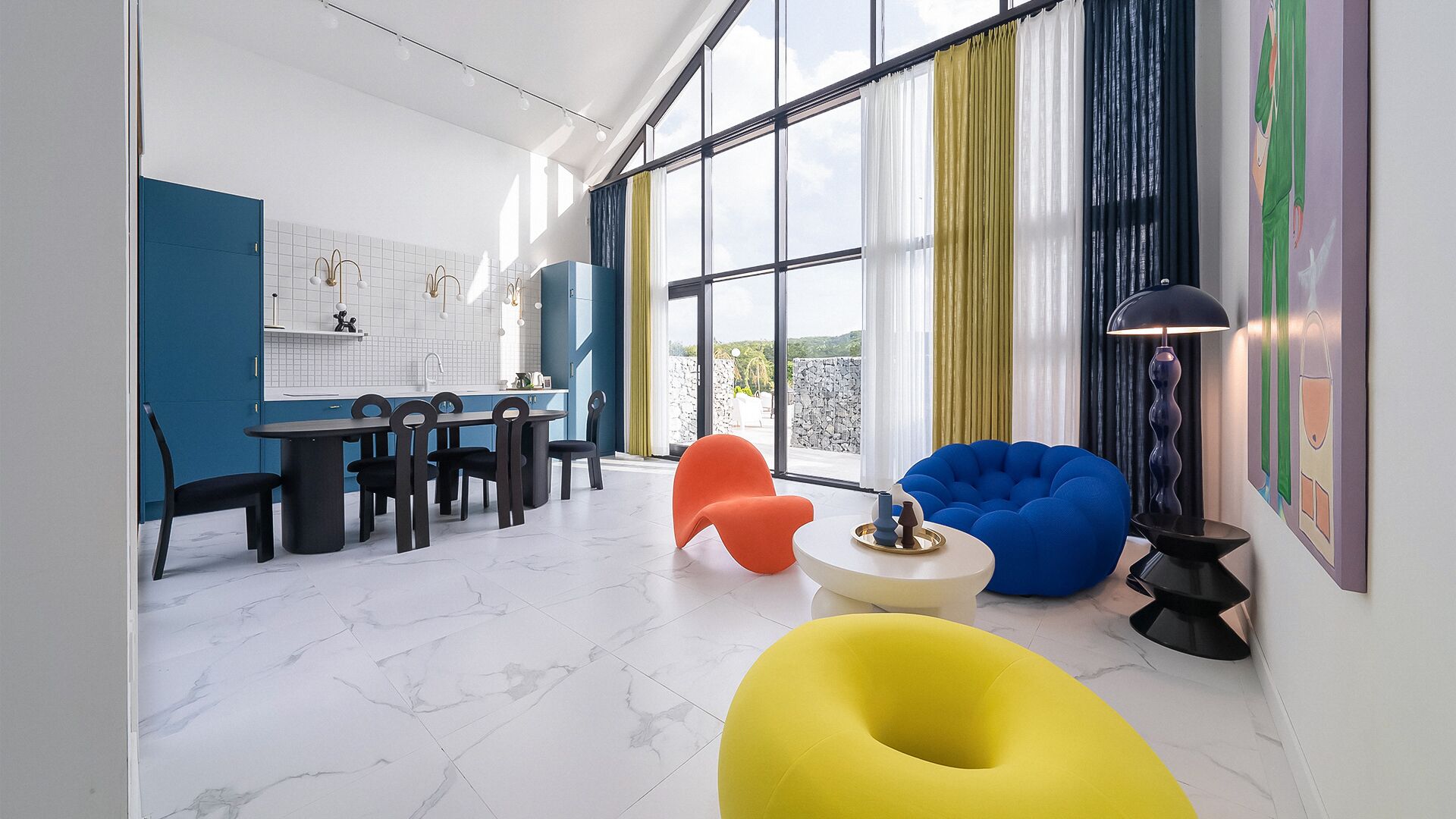 A modern living room with a dining area, large windows, and colorful chairs.