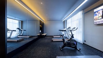 A modern gym with treadmills, an elliptical, and a bench.