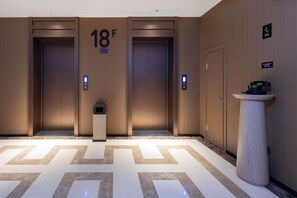 A modern elevator with a digital display, a floor number sign, and a small trash bin. - Meilun Hotel Xian Qujiang Convention Center Mixc (Xi'an)