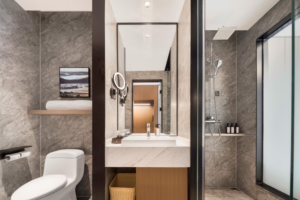 A modern bathroom with a toilet, sink, and shower.
