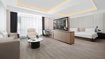 Habitación de hotel moderna con cama, escritorio, silla y televisor.