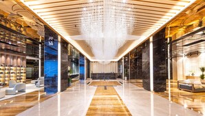 A spacious lobby with a central reception desk, modern seating areas, and a decorative chandelier. - Meilun Hotel Xian Qujiang Convention Center Mixc (Xi'an)